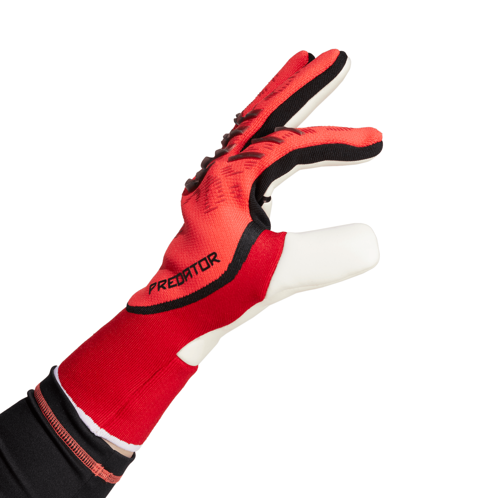Red and black Adidas Predator goalkeeper glove shown from a side profile against a solid green background.