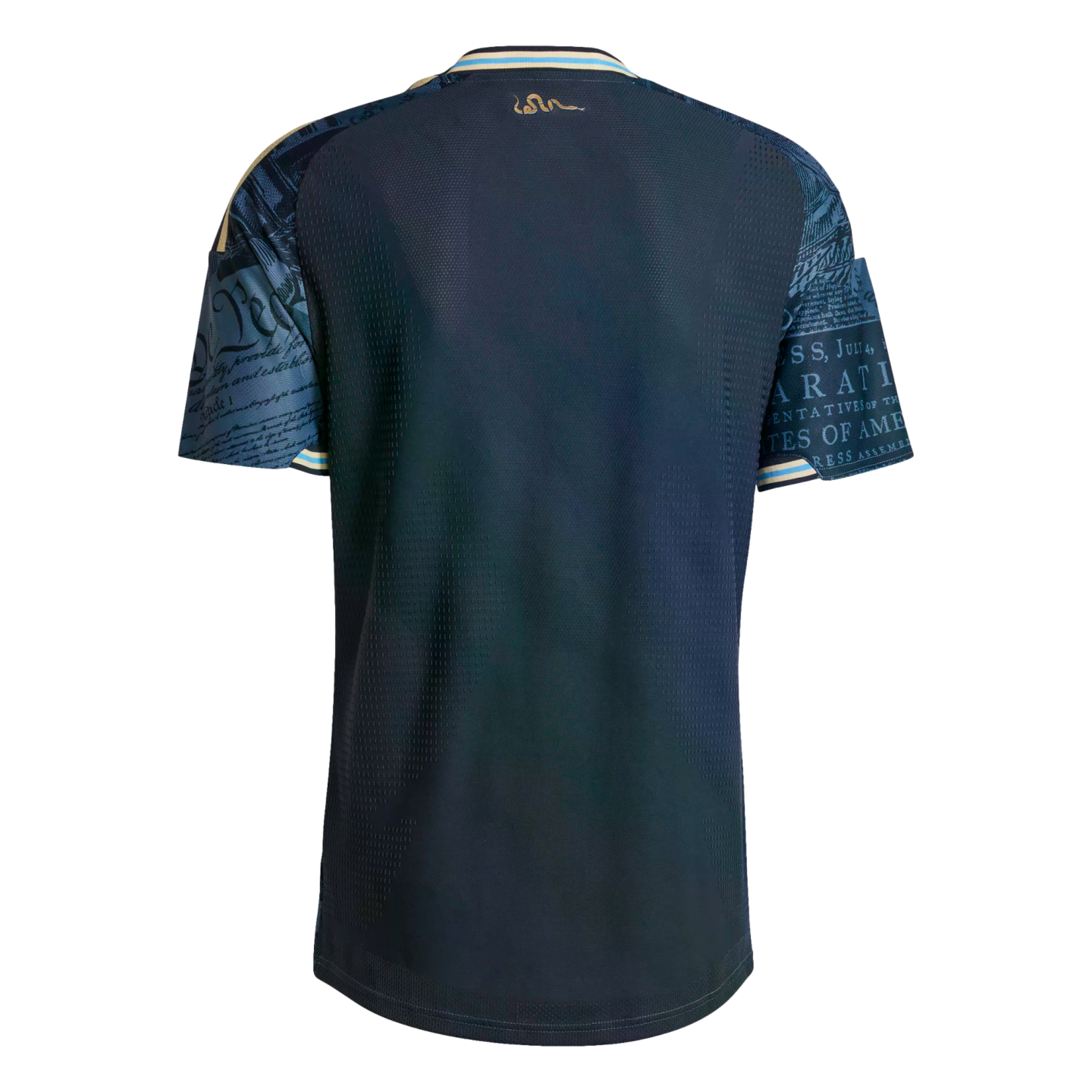 Back of a navy soccer jersey with US Constitution script on the sleeves, a gold snake logo below the collar, and light blue trim on the neck and cuffs.