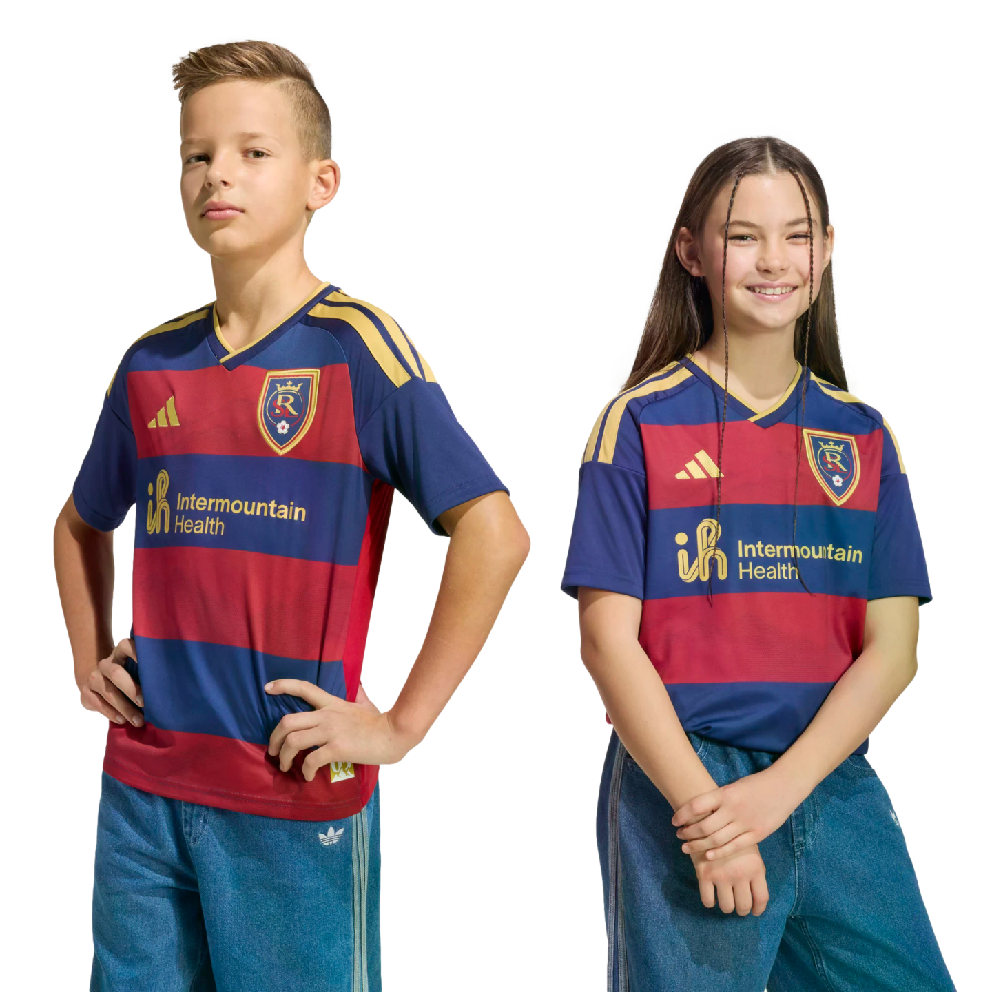 Two children, a boy and a girl, pose in matching navy and red striped soccer jerseys with gold logos against a black background.