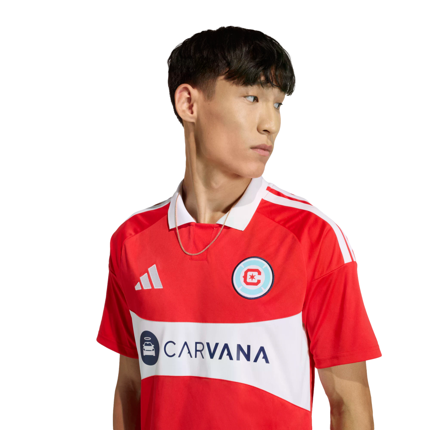 A man in a red Chicago Fire FC jersey with a white horizontal band featuring the Carvana logo. The shirt has a white collar and Adidas stripes on the shoulders.