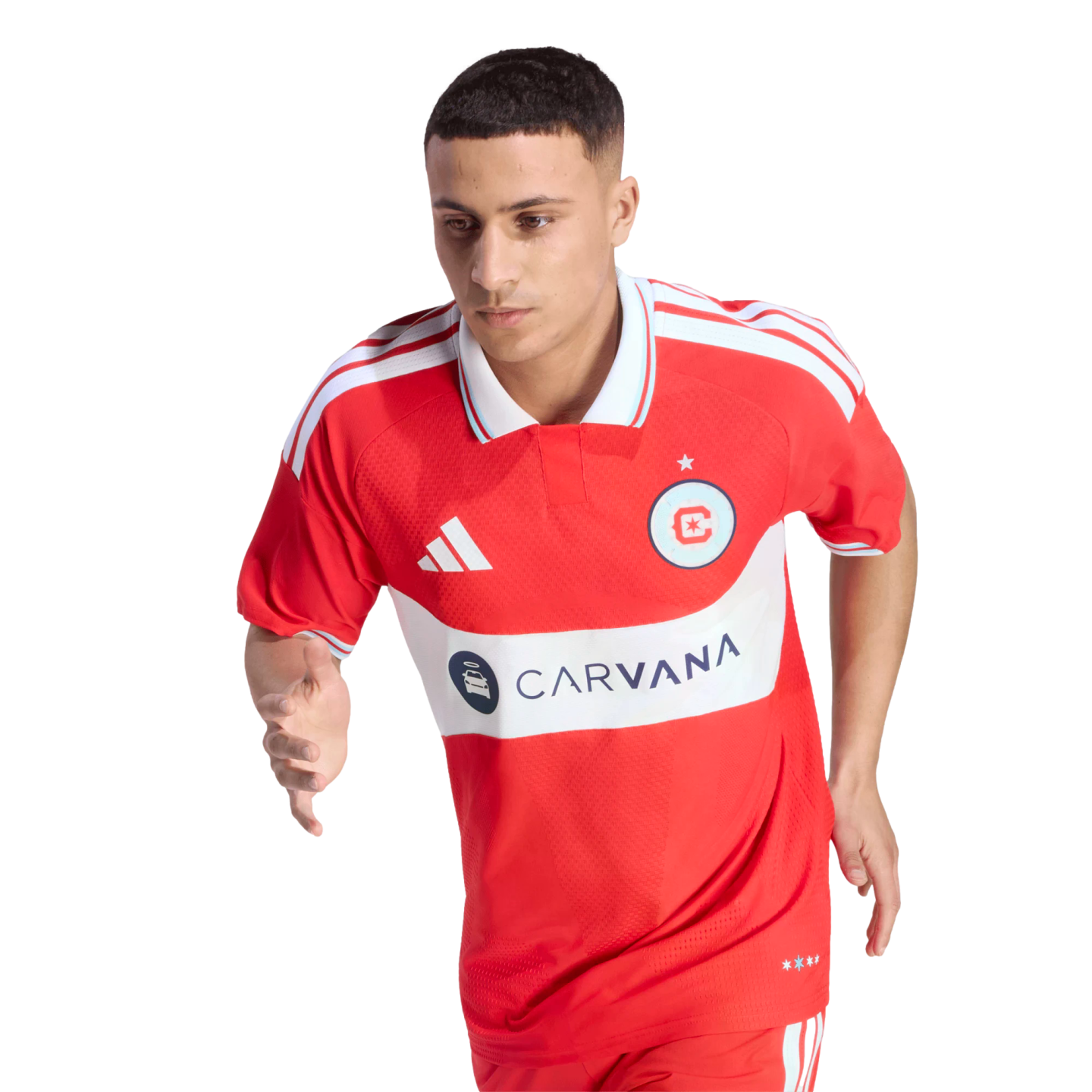 A male soccer player in a red Chicago Fire FC jersey with "CARVANA" logo, captured in a running pose against a black background.