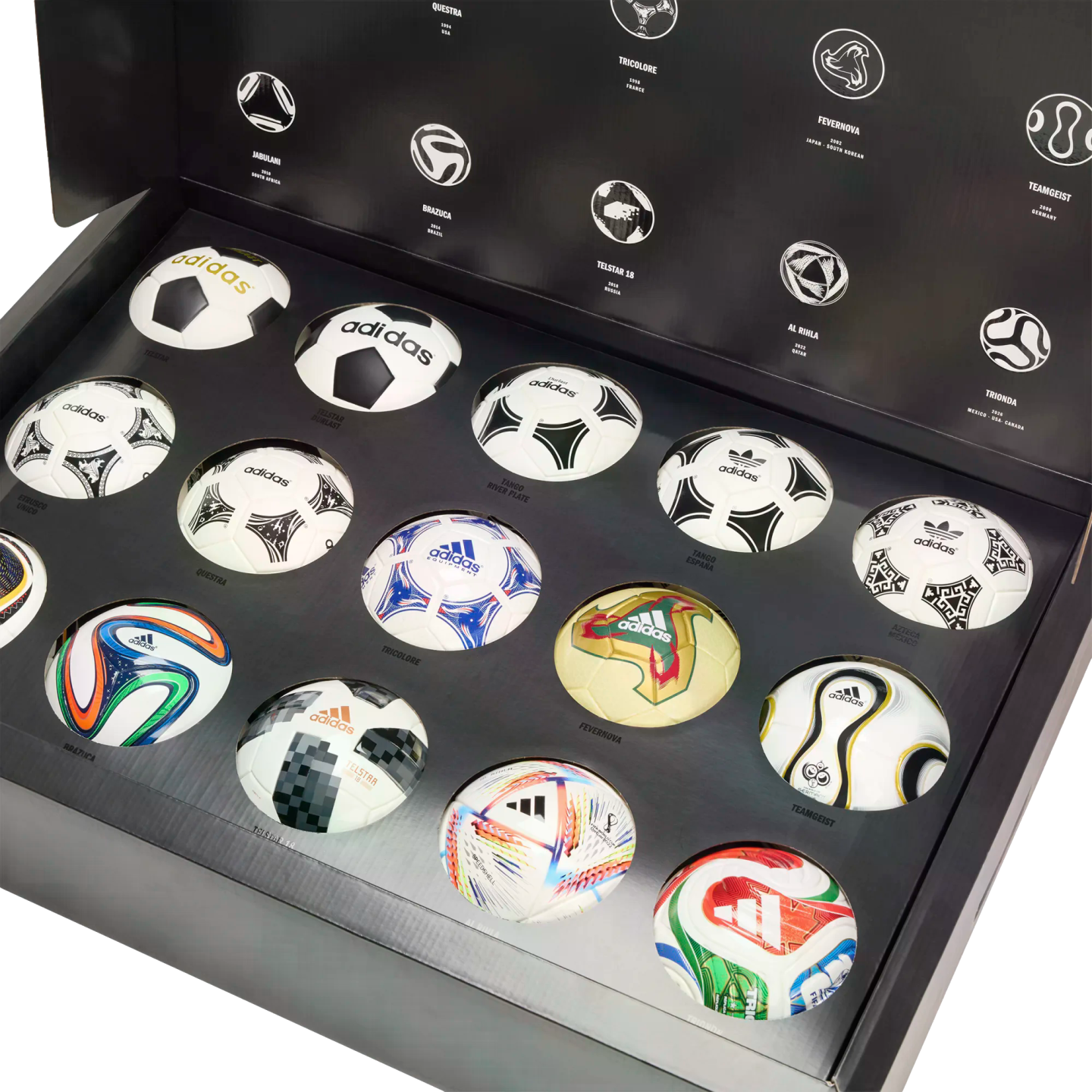 A collection of miniature Adidas FIFA World Cup soccer balls showcased in a large black presentation box, featuring iconic match ball designs from various years.