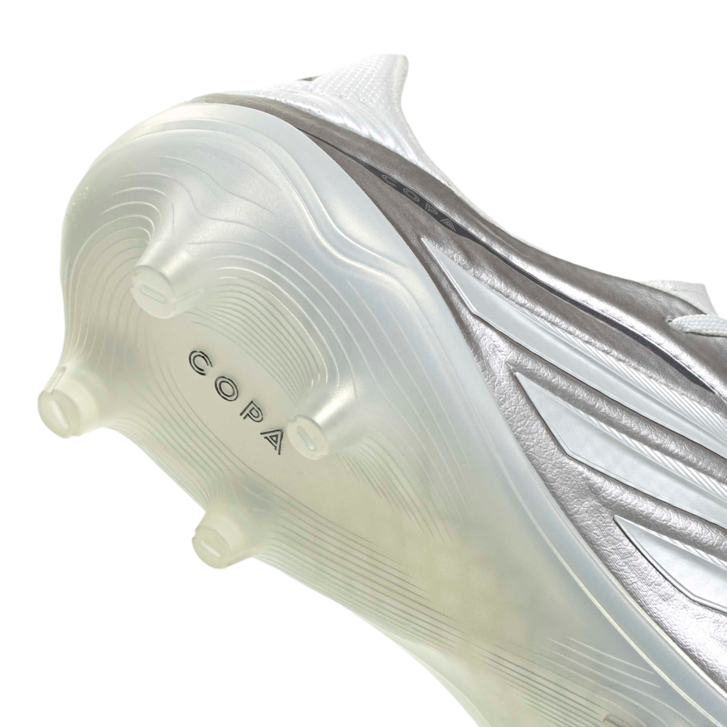 A close-up view of the heel and sole of a metallic silver soccer cleat. The translucent white sole plate features textured wavy ridges and "COPA" branding.