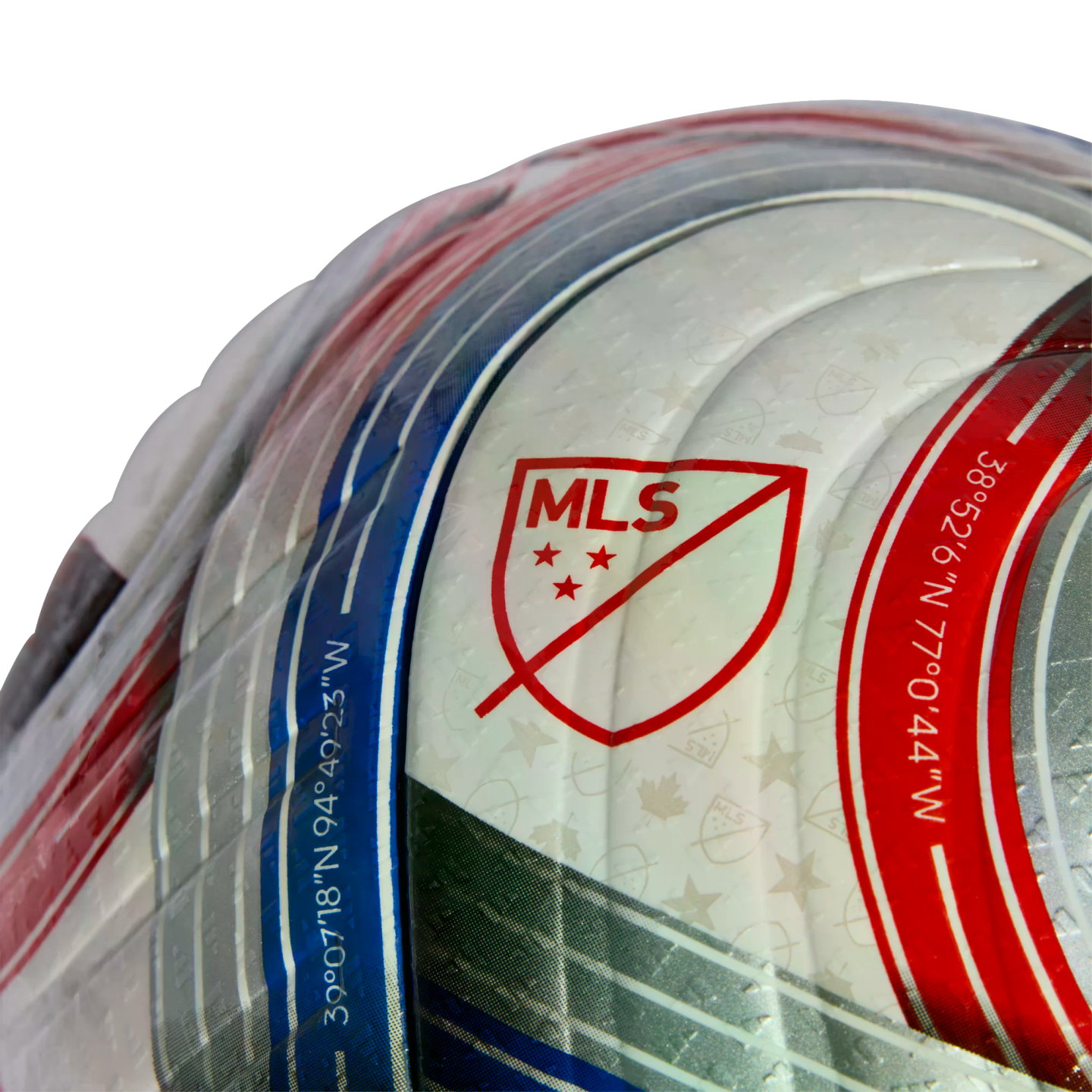 Close-up of an MLS soccer ball featuring the red league logo and geographic coordinates printed along curved blue and red stripes on a white textured surface.