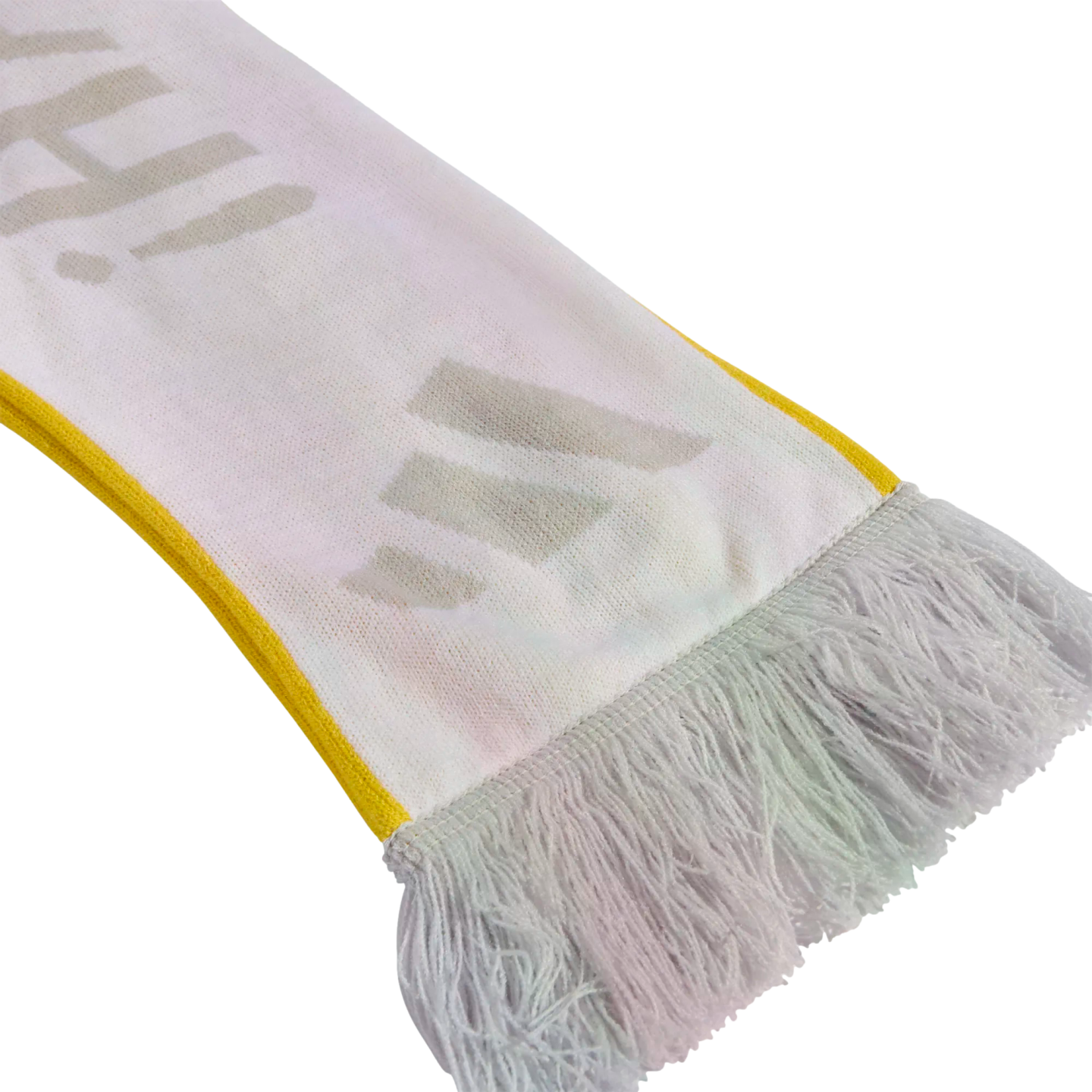A close-up of a white knitted scarf with yellow edges and white tassels, featuring faint grey letters printed on the fabric.