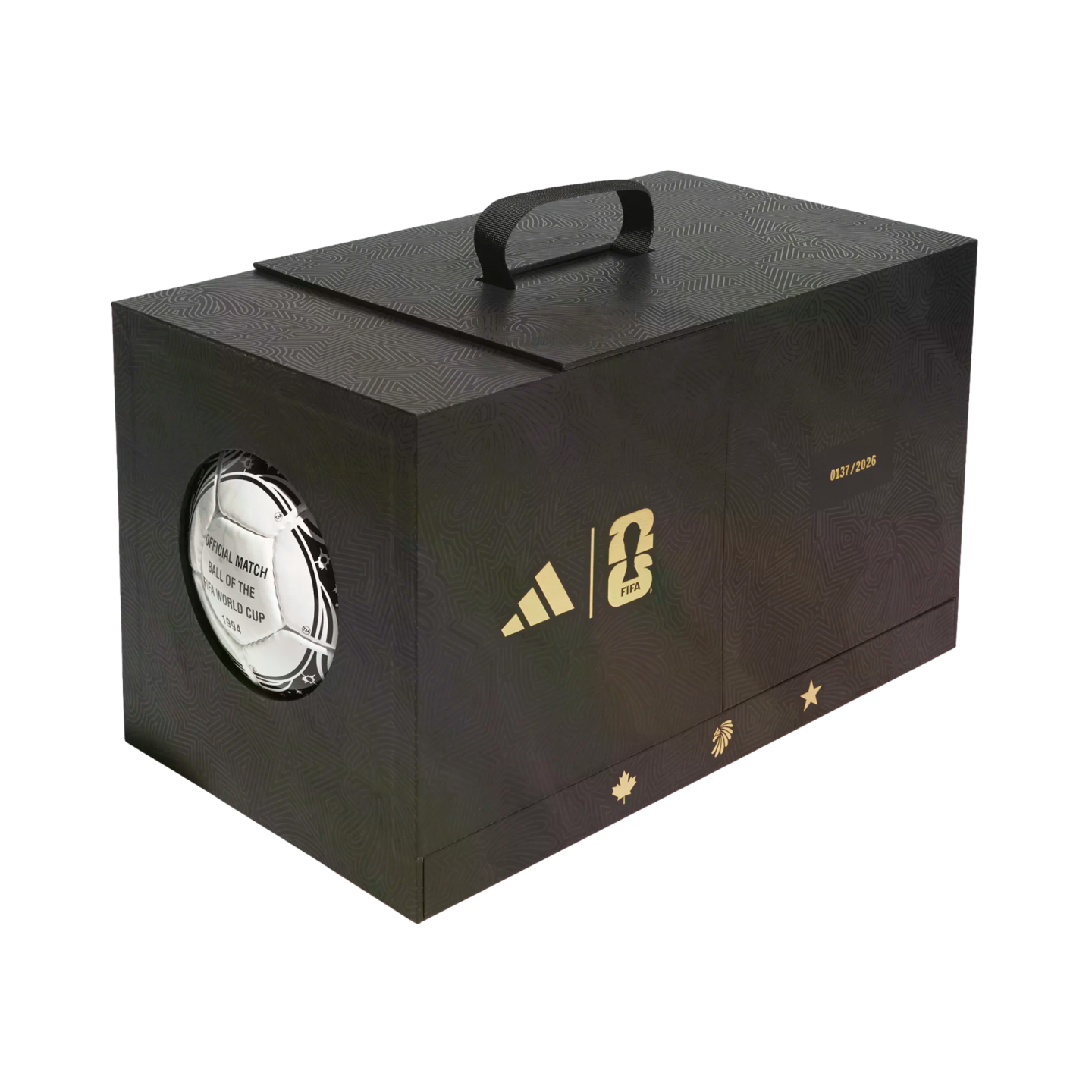 A black commemorative box with gold Adidas and FIFA World Cup 26 logos, host nation icons, and a window displaying a 1994 official match ball.