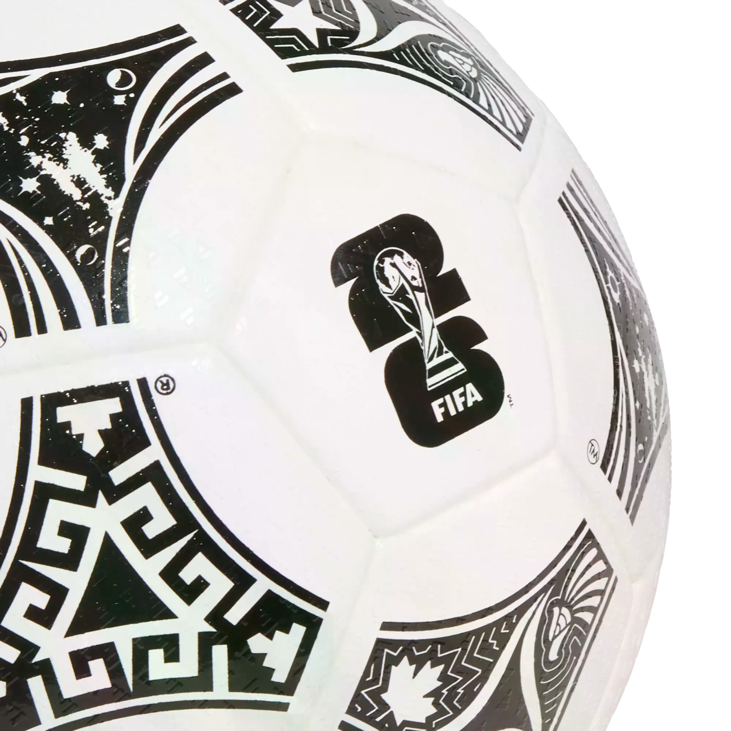 Close-up of a white soccer ball featuring the black FIFA World Cup 2026 logo and decorative panels with cultural patterns like a maple leaf and geometric designs.
