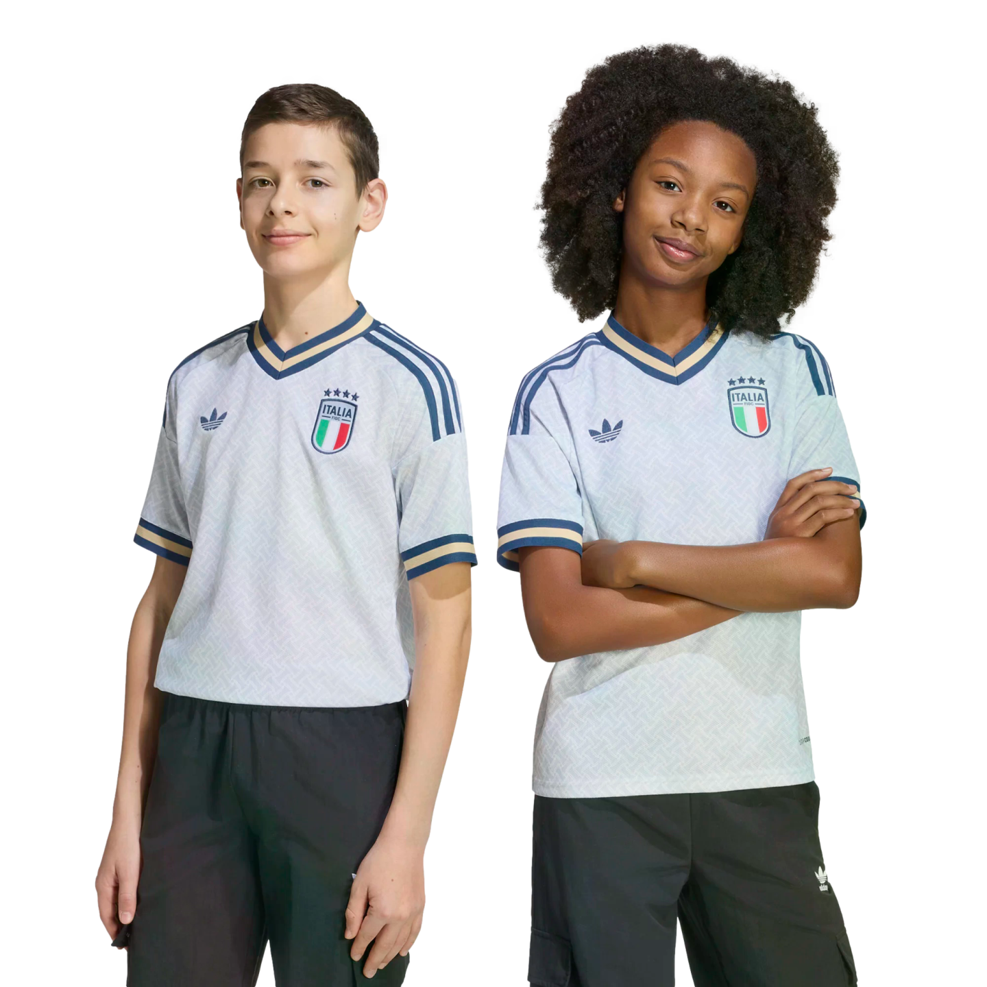 A boy and a girl posing in light blue Adidas Italy national team soccer jerseys and dark bottoms against a black background.