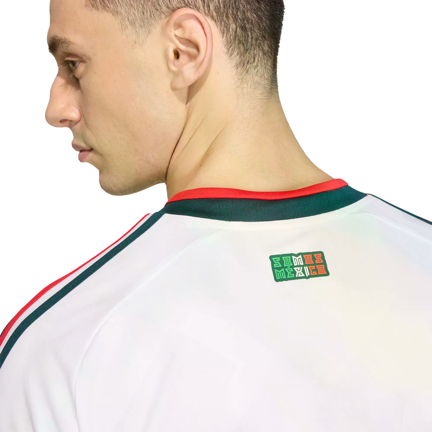Profile of a man wearing a white jersey with red and green accents. A "SOMOS MÉXICO" graphic is visible on the upper back below the collar. Black background.