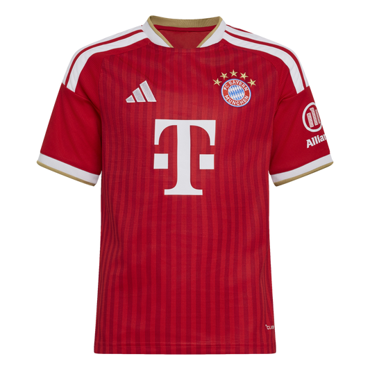 A red FC Bayern Munich football jersey with white and gold accents, featuring the team crest and a large white "T" sponsor logo on the front.