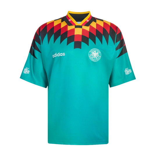 Teal Adidas Germany soccer jersey with a red, yellow, and black geometric diamond pattern across the chest and shoulders, featuring the national team crest and white Adidas logo.
