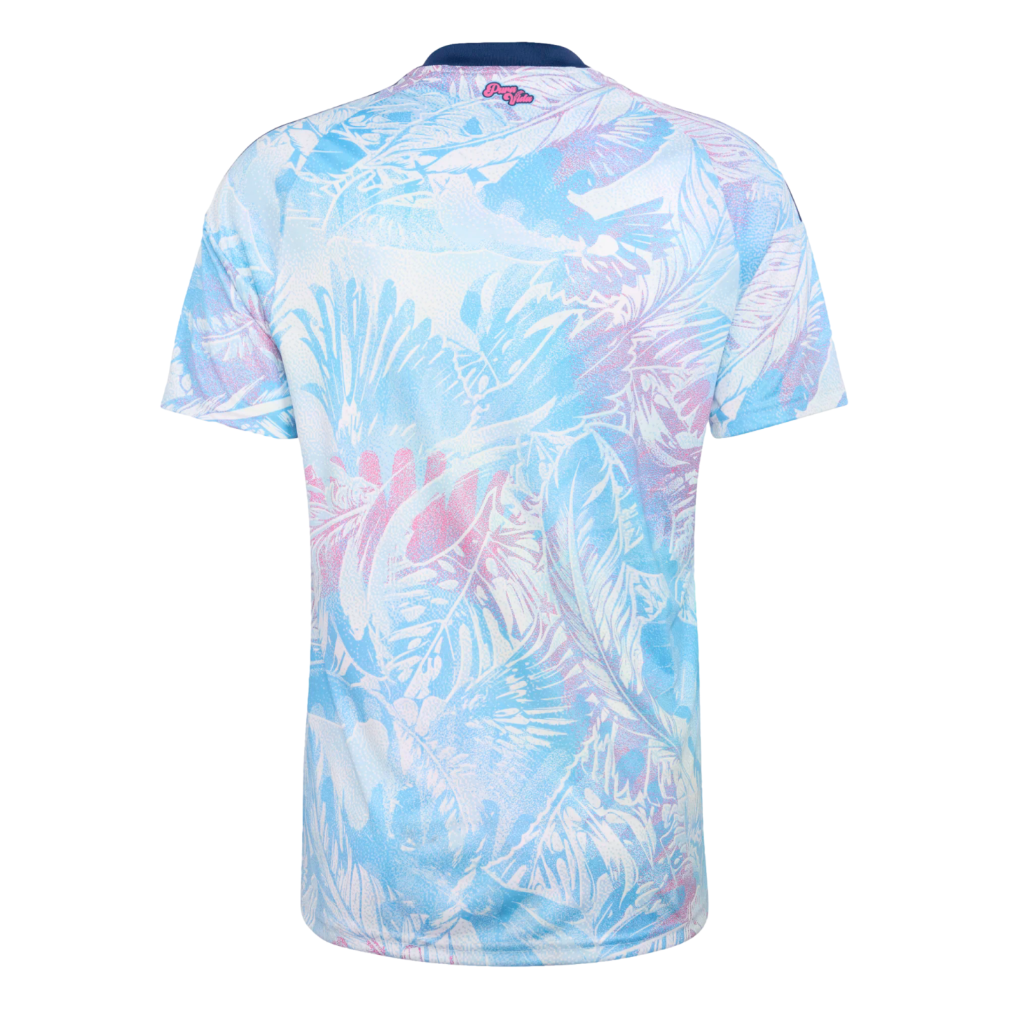Back of a short-sleeved jersey with a light blue and pink tropical leaf print on white. It has a navy blue collar and small pink "Pura Vida" text at the top center.