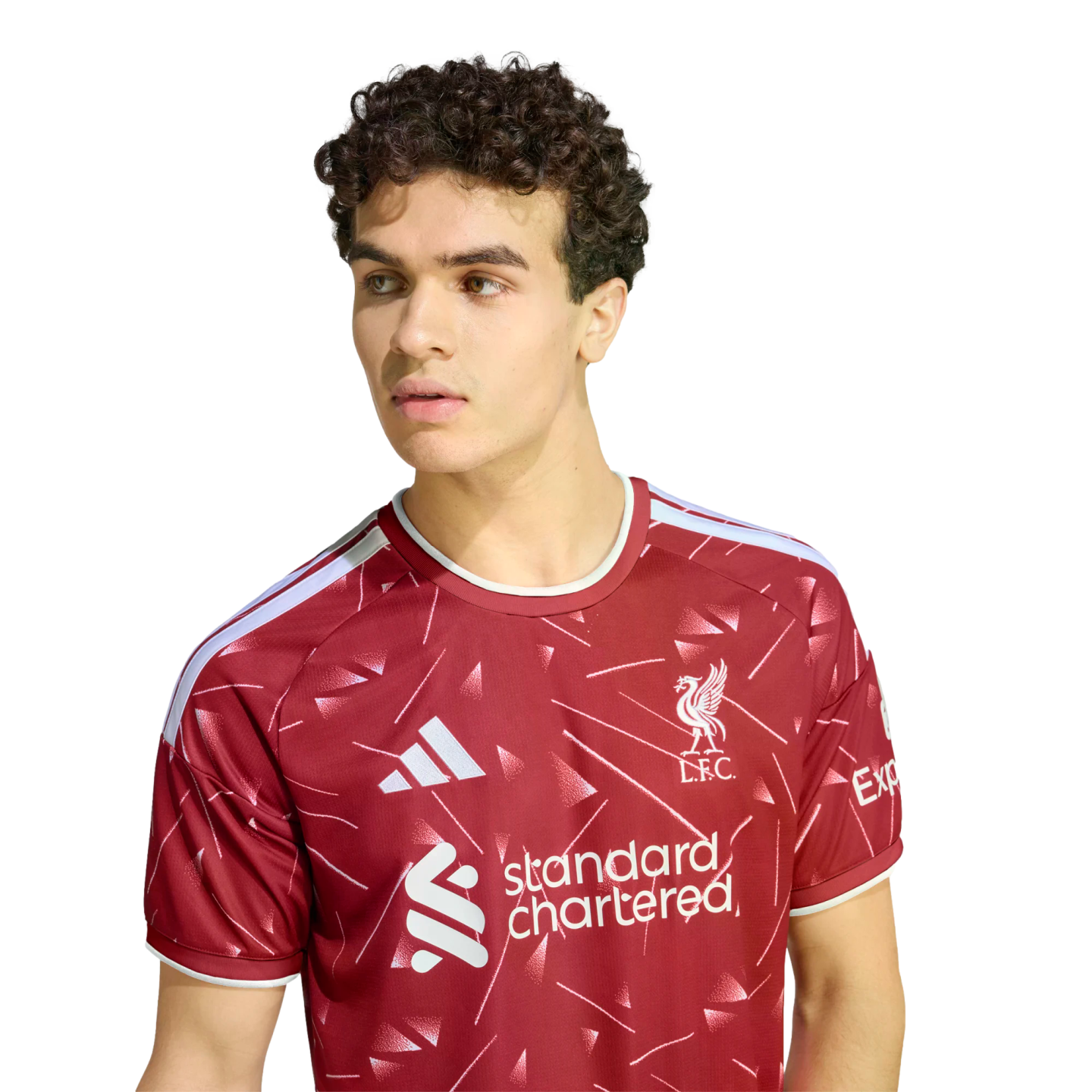 Man with curly brown hair wearing a red Liverpool FC soccer jersey, looking to the side against a plain white background.