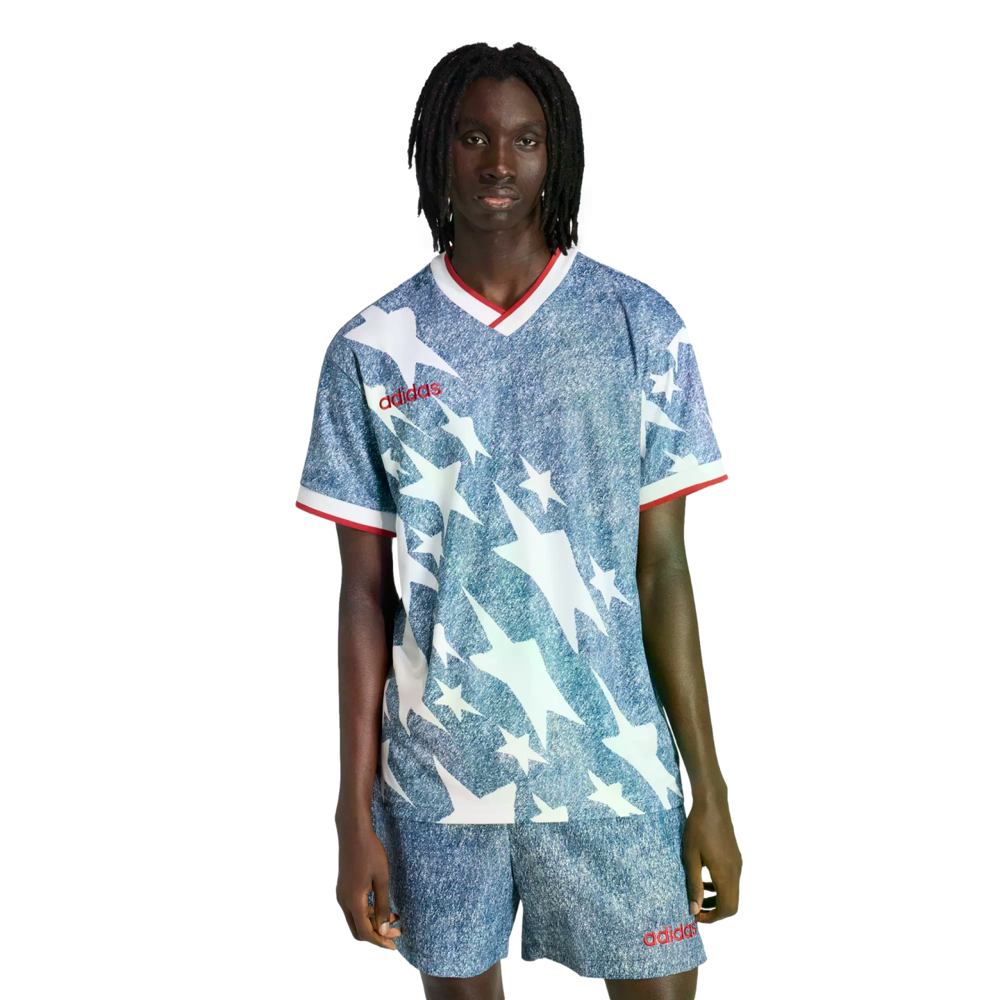 A person wearing a blue denim-textured Adidas soccer kit featuring white stars and red trim, against a black background.