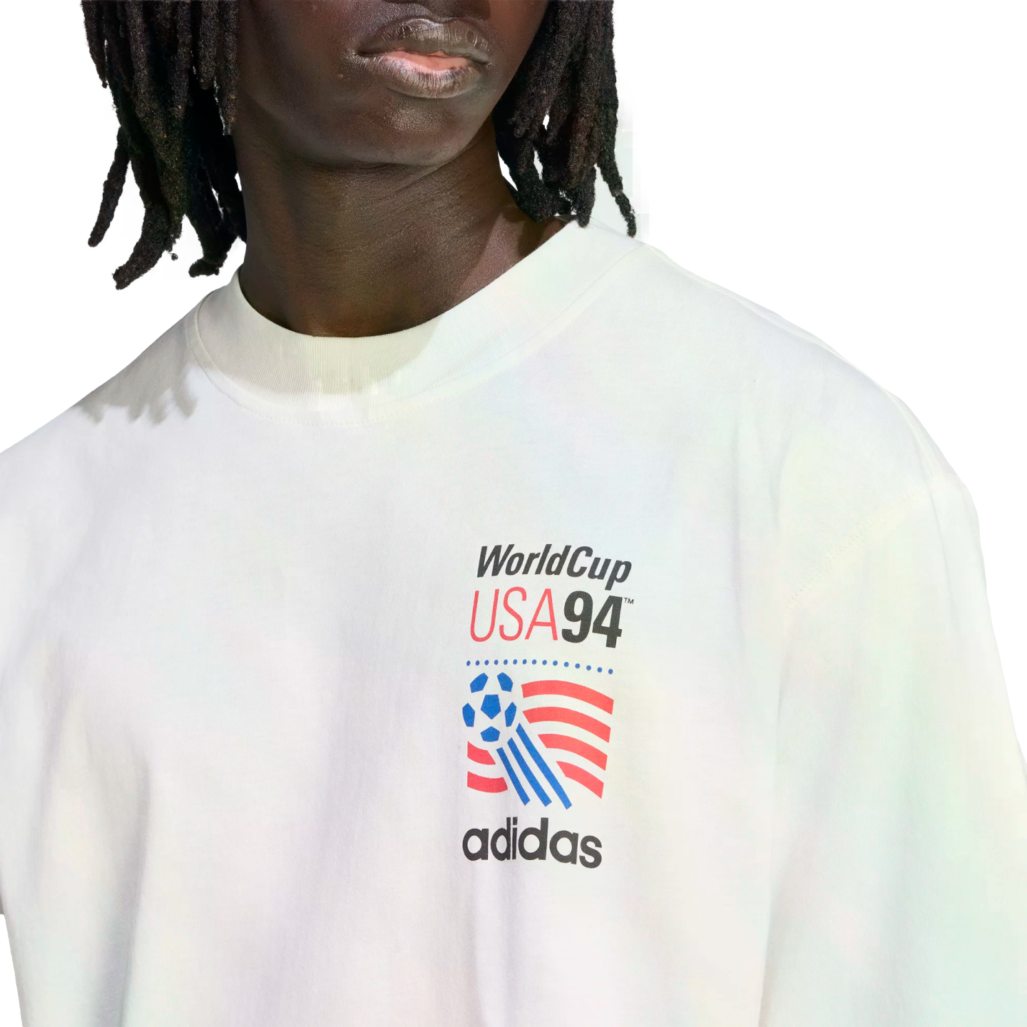 A person wearing a white Adidas t-shirt with a World Cup USA 94 graphic on the chest.