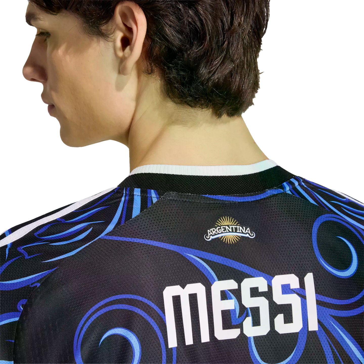 Back view of a person wearing a black Argentina soccer jersey with blue swirl patterns and "MESSI" printed in bold white letters.