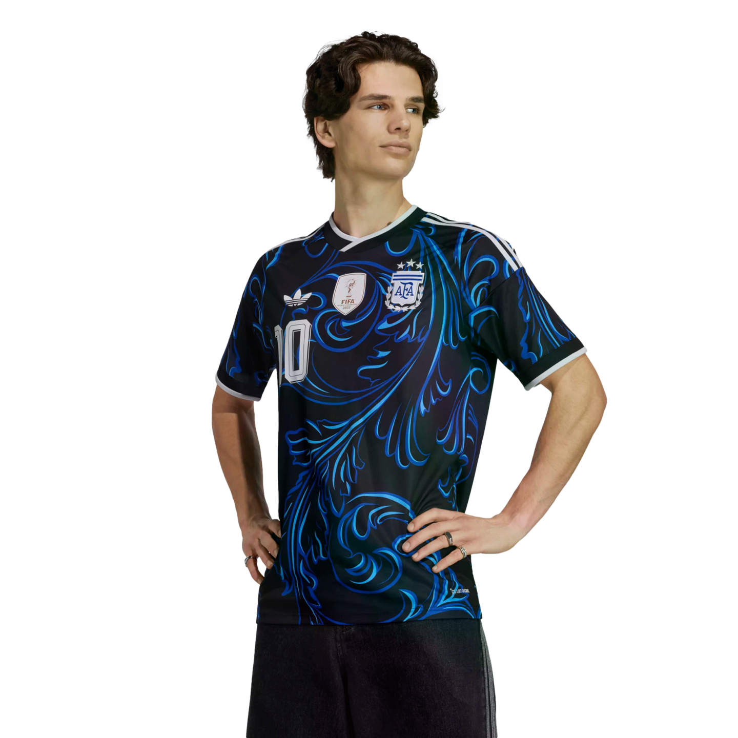 Man wearing a black Argentina football jersey with blue swirling patterns and the number 10, standing with hands on hips against a black background.