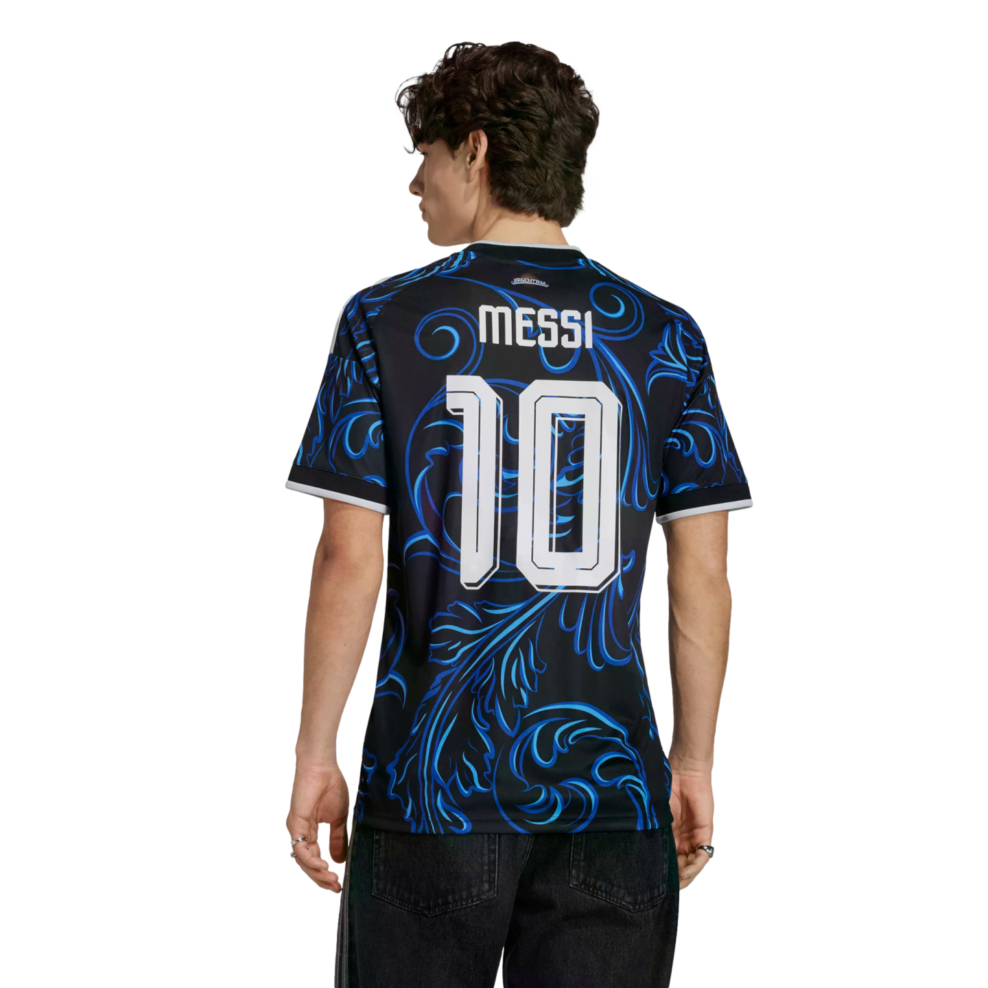 Rear view of a man wearing a black and blue patterned soccer jersey with "MESSI 10" on the back, against a solid black background.