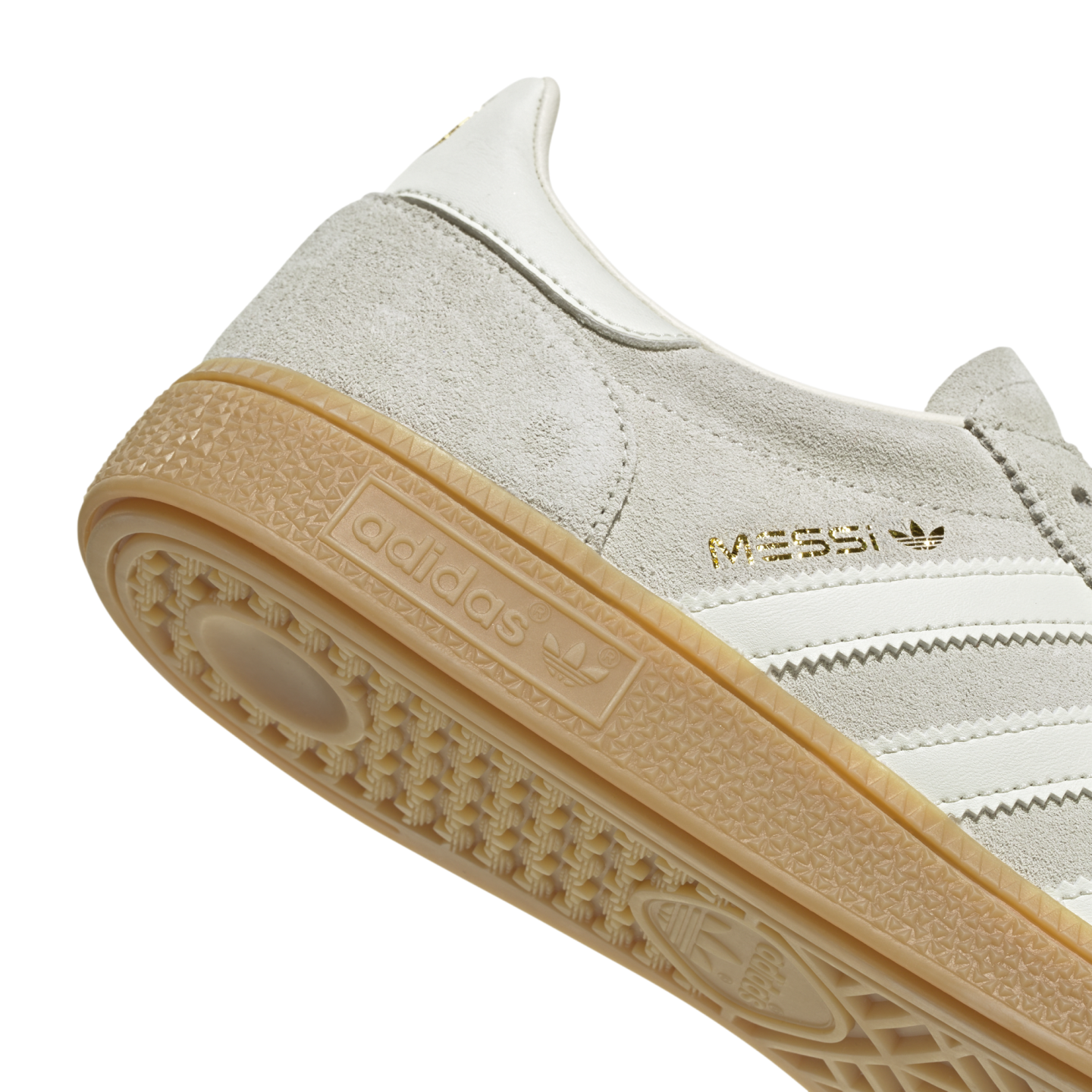 Close-up of a grey suede Adidas sneaker featuring gold "MESSI" branding and a gum rubber outsole.