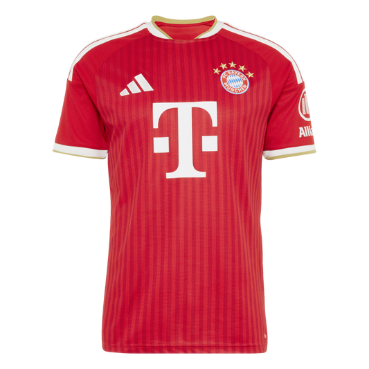 A red soccer jersey with vertical stripes, featuring the FC Bayern Munich crest, white Adidas logo, and white "T" sponsor logo. White and gold trim accents the collar and sleeve cuffs.