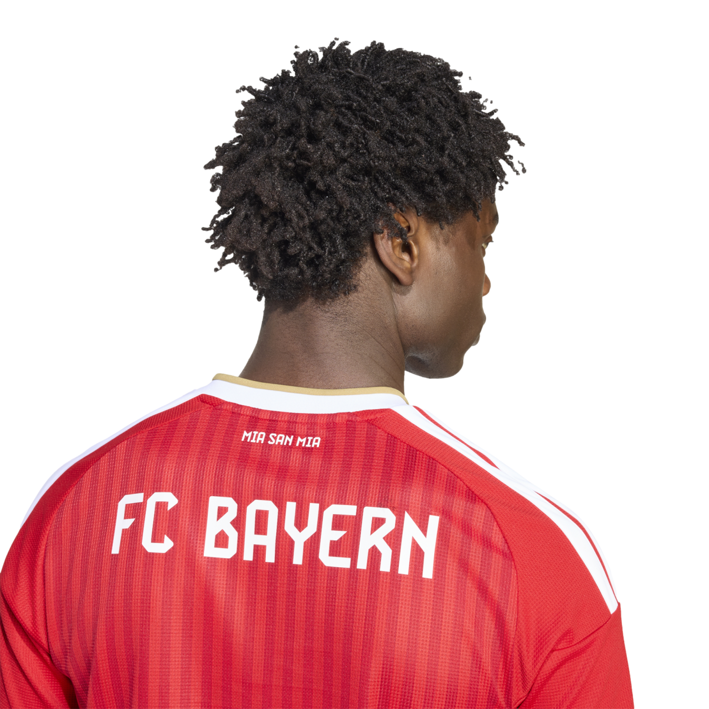 Back view of a person with dark curly hair wearing a red striped FC Bayern soccer jersey with white "FC BAYERN" and "MIA SAN MIA" lettering.