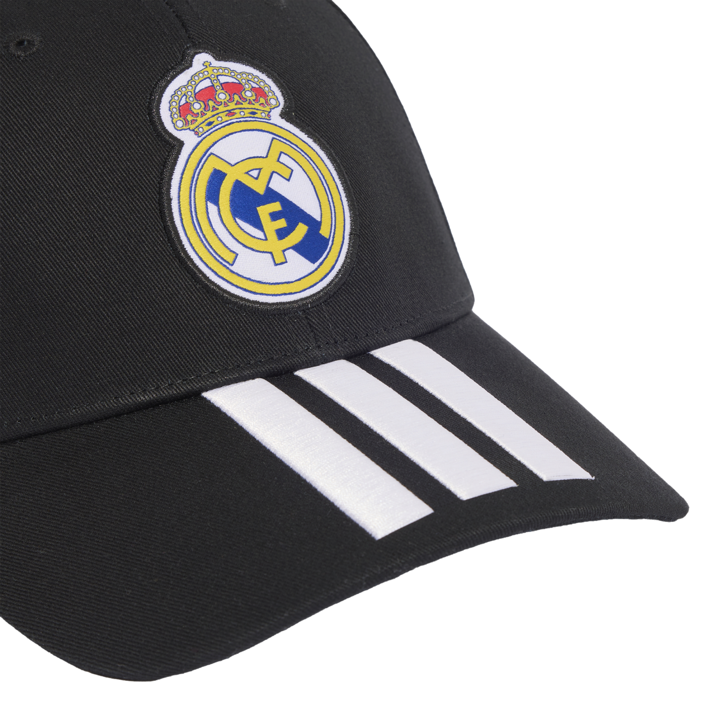 A black baseball cap featuring the Real Madrid club crest on the crown and three white Adidas stripes on the visor.