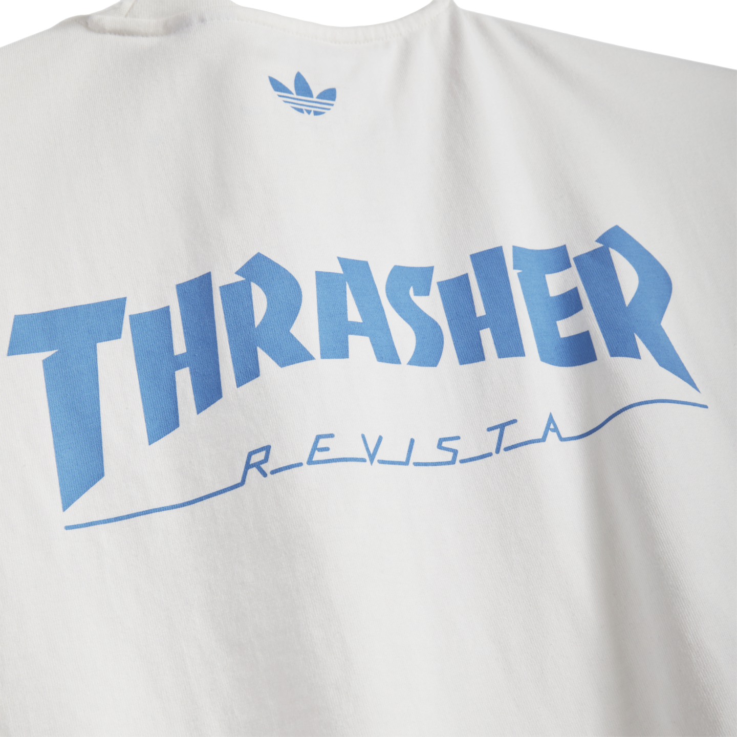 White t-shirt featuring light blue Adidas logo, large arched 'THRASHER' text, and 'REVISTA' in stylized blue script underneath.