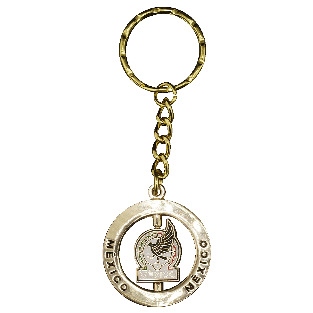 Gold-toned keychain featuring a spinning circular medallion with an eagle emblem and the word "MÉXICO" engraved on the outer ring.