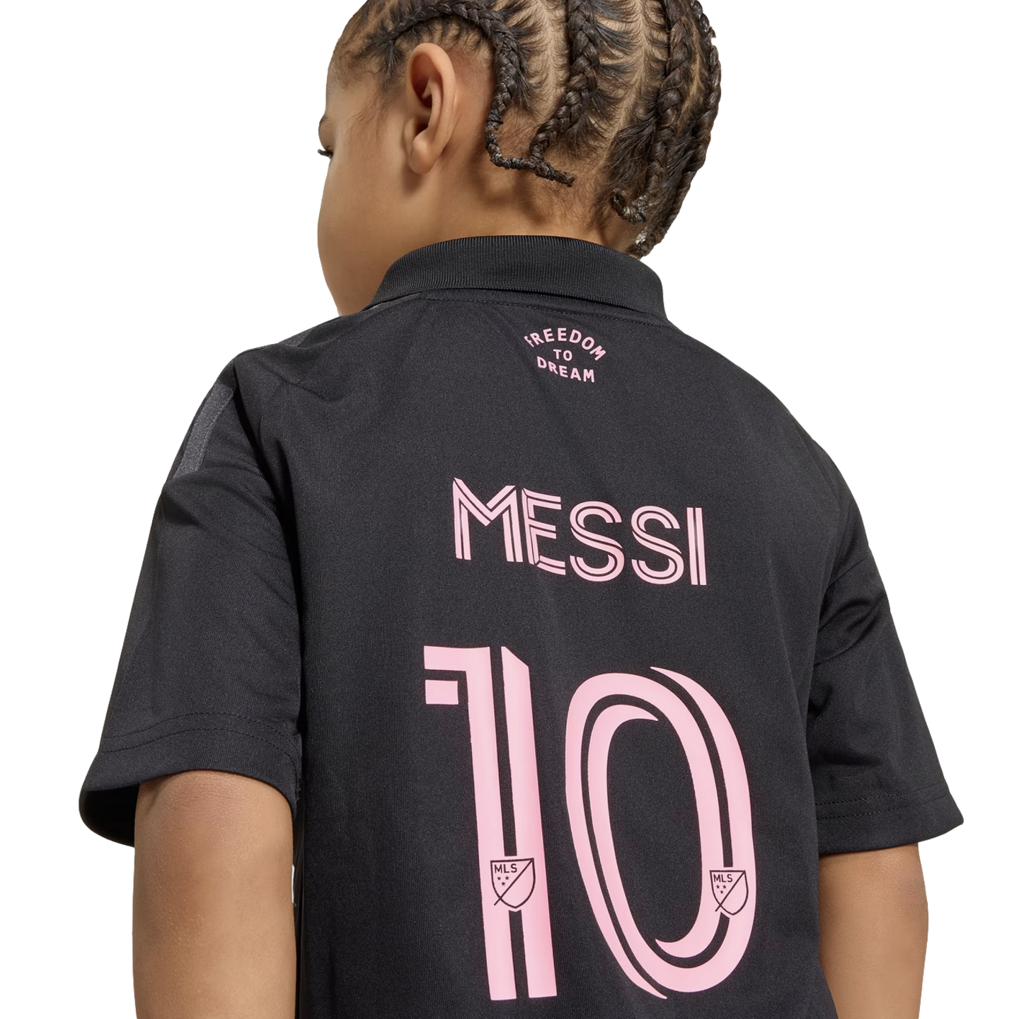 Back view of a child with braided hair wearing a black soccer jersey with "MESSI" and the number "10" printed in pink below the words "FREEDOM TO DREAM".
