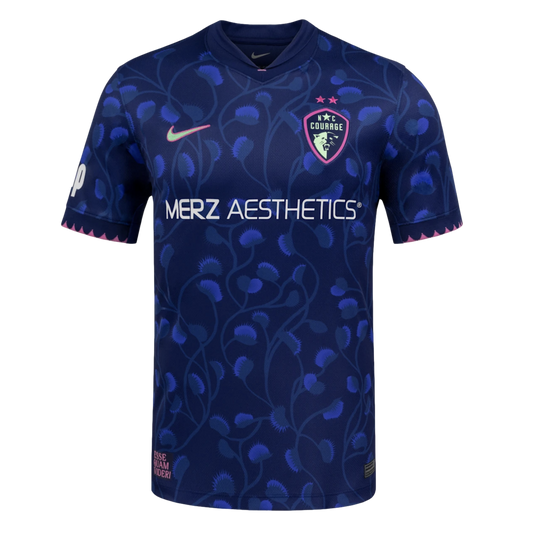 Navy soccer jersey with blue Venus flytrap patterns, white Merz Aesthetics text, a pink Nike swoosh, and NC Courage crest. Jagged pink trim lines the sleeve cuffs and bottom hem.