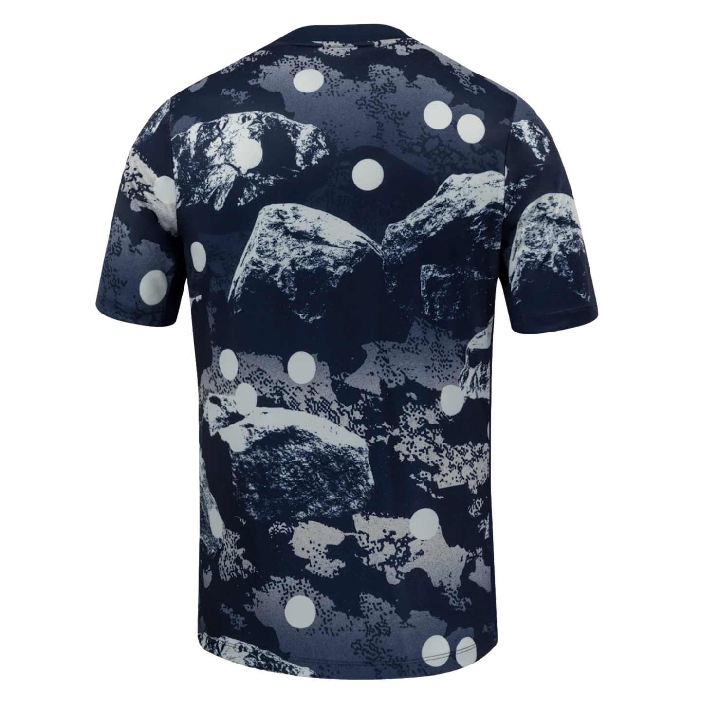 Back view of a short-sleeved dark blue t-shirt with an abstract grey rock and large white polka dot pattern.