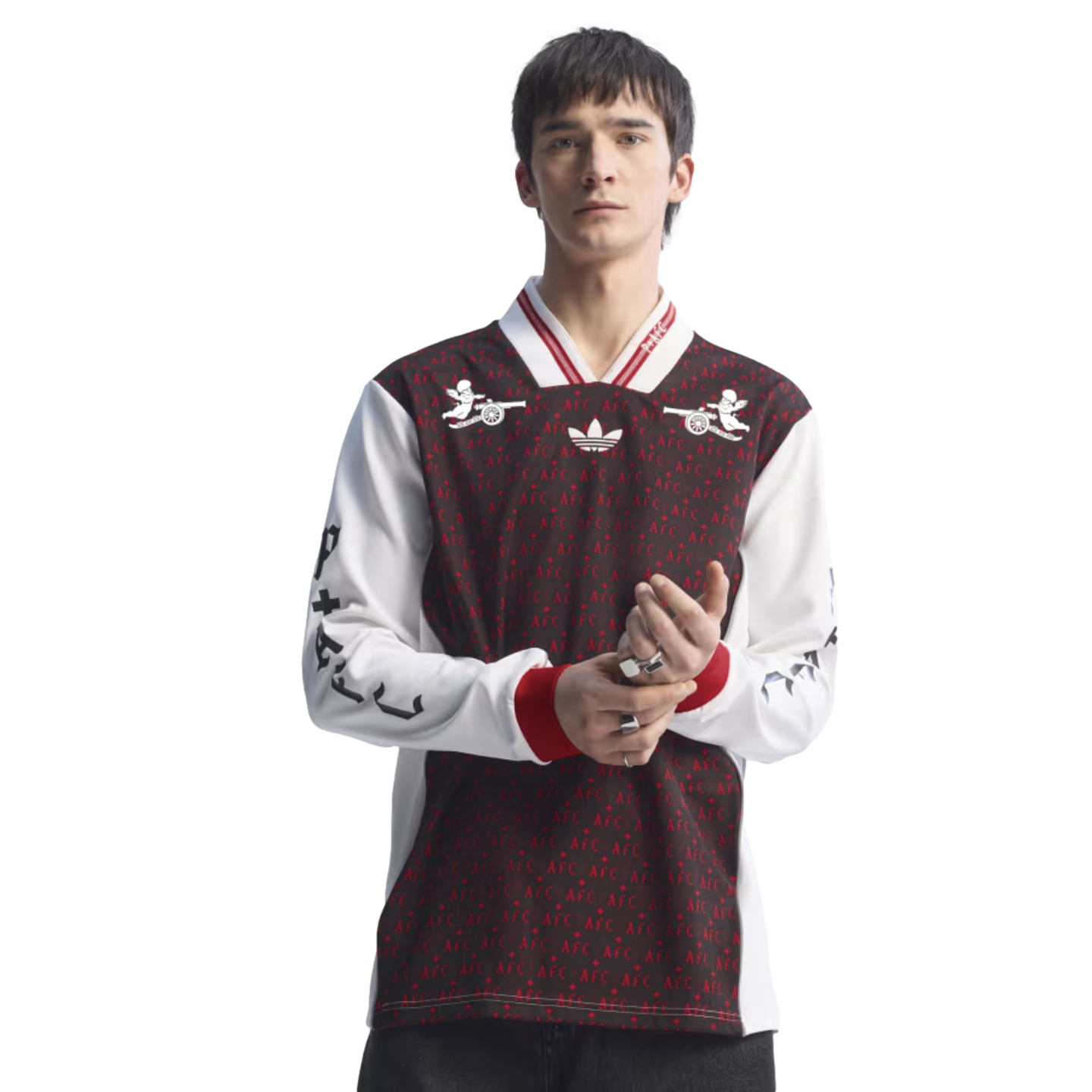 Man modeling a long-sleeved maroon and white Adidas jersey with "AFC" patterns and cherub graphics against a solid black background.