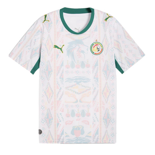 A white Senegal national football team away jersey featuring a green V-neck collar and sleeve trim. The shirt has a faint, multi-colored geometric and lion-head pattern across the front, with the Puma logo on the right chest and the Senegalese football fe
