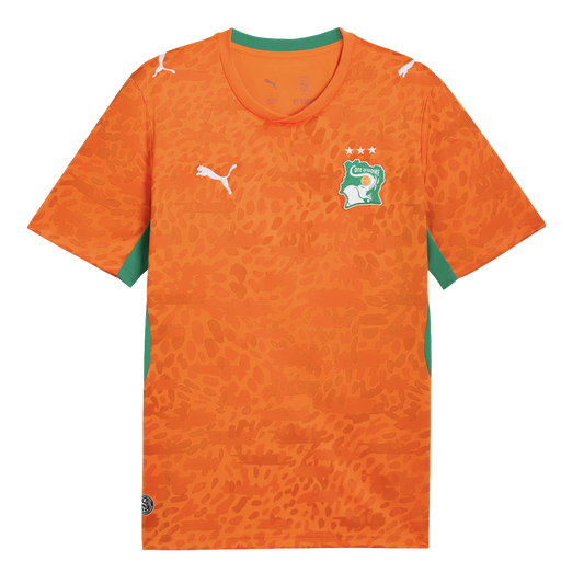 An orange Puma soccer jersey for the Côte d'Ivoire national team. It features an all-over tonal leopard print pattern, a green collar, and green side panels. The team's elephant crest with three stars is on the left chest, and white Puma logos are on the 