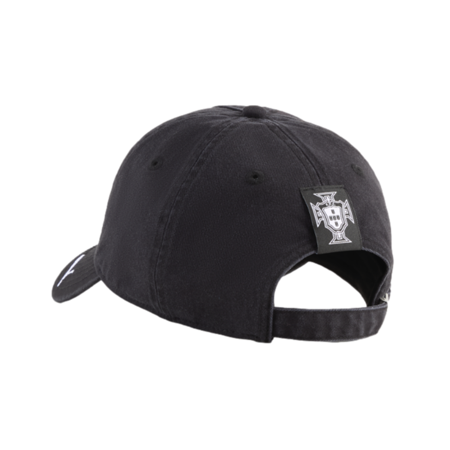 A rear-side view of a black baseball cap featuring a small white crest logo on a square patch above the adjustable strap, set against a solid black background.