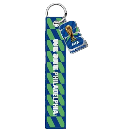 A blue and green patterned keychain with a long fabric strap reading "WE ARE PHILADELPHIA" and a small charm featuring the FIFA World Cup trophy and "FIFA PHILADELPHIA."