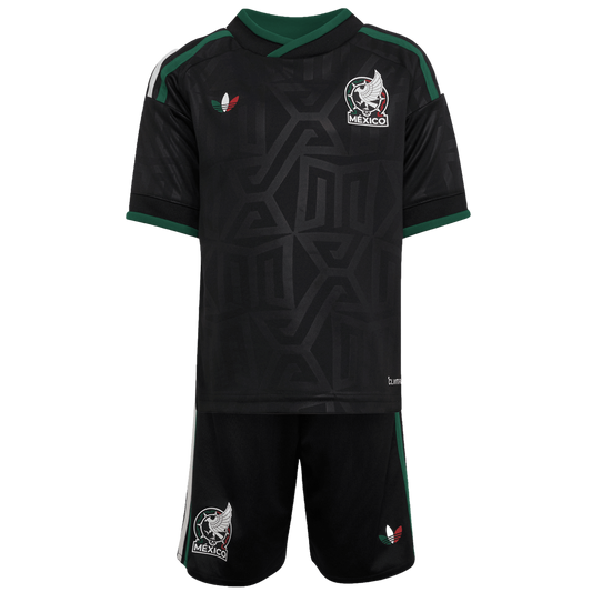 A black Mexico national team soccer kit featuring an Aztec-inspired pattern, team crest, and green and white accents on the jersey and shorts.
