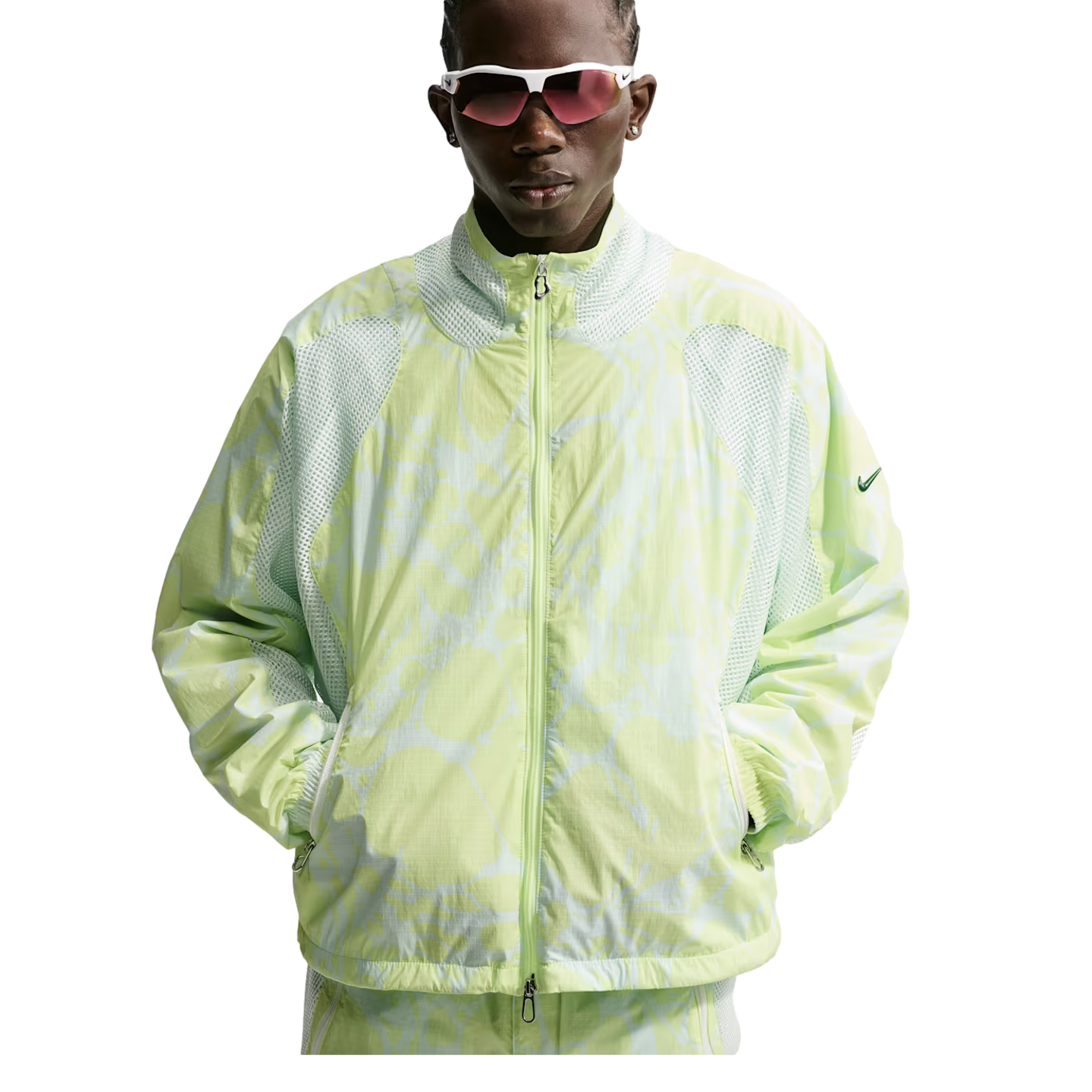A person wearing white-framed sunglasses and a light green patterned Nike zip-up jacket with mesh panels, posing against a white background.