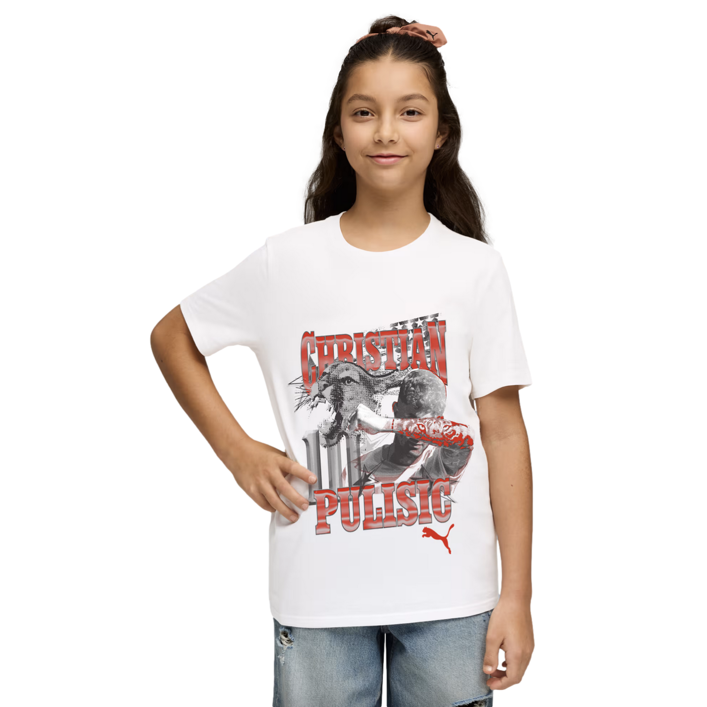 Young girl wearing a white Christian Pulisic graphic t-shirt and blue jeans, standing against a black background.